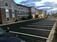 a parking lot at dusk with a car parked in it